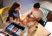 Two people unboxing an iPhone while sitting at a table